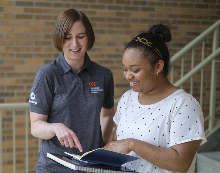 2 people looking at a notebook