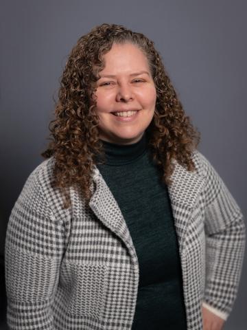 Trish Caldwell wearing a black shirt and light gray suit